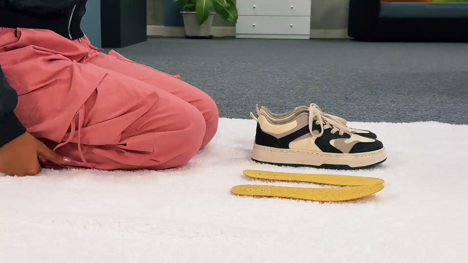 girl-kneeling-on-carpet-next-to-shoe-and-in-soles